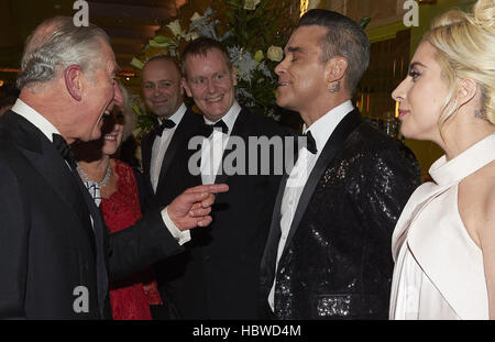 La duchesse de Cornouailles (caché) et le Prince de Galles (à gauche) parle avec des chanteurs Lady Gaga et Robbie Williams qu'ils arrivent à la Royal Variety Performance à l'Eventim Apollo à Hammersmith, Londres. Banque D'Images