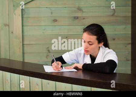 La femme médecin est assis à une table ayant fermé les yeux pour la fatigue Banque D'Images