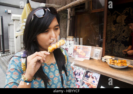 Meilleur thai woman eating Mitarashi Dango snack japonais style à Kawagoe ville est également connue sous le nom de Little Edo sur Octobre 19, 2016 à Saitama, Japon Banque D'Images