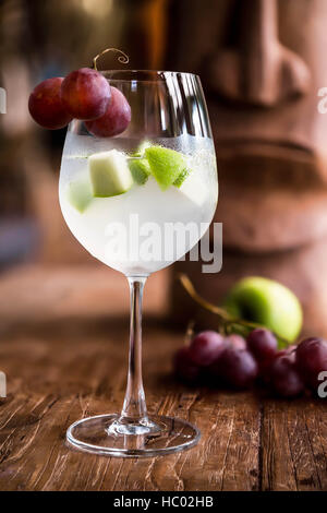 Cocktail Sangria blanche avec des raisins rouges, de pomme verte et de chardonnay. Banque D'Images