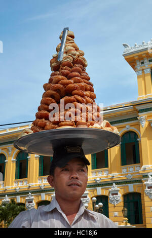 Vente de pâtisseries, de l'homme Bureau de Poste Central historique, Ho Chi Minh Ville (Saigon), Vietnam Banque D'Images