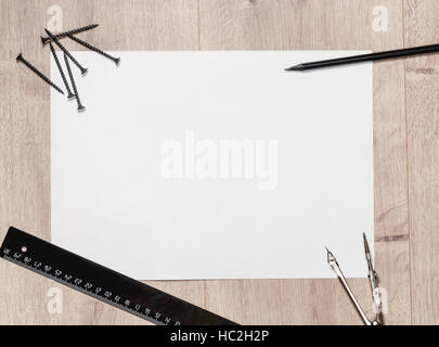 Télévision composition de feuille de dessin vide et de vis, une règle, crayon, compas sur table en bois. Réparateur de l'espace de travail avec copie espace.. Banque D'Images