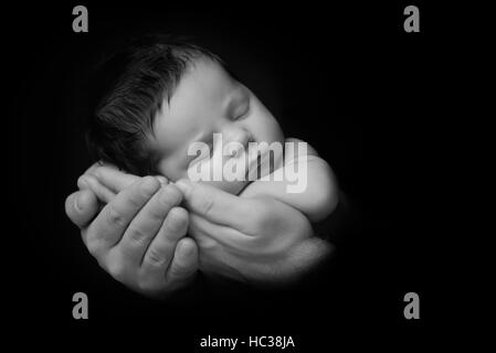 Bébé nouveau-né pris libre en main du père - noir et blanc Banque D'Images