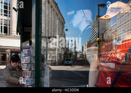 Réflexions dans une fenêtre d'une des boutiques du centre-ville de Belfast, en Irlande du Nord, Royaume-Uni. Tous les grands magasins et les chaînes sont l Banque D'Images