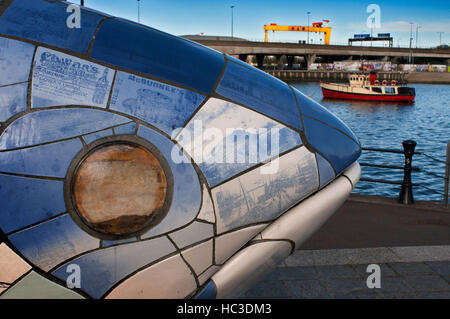 Le gros poisson sculpture par John Kindness, Donegall Quay, River Lagan, Belfast, Irlande du Nord, Royaume-Uni. En arrière, la coque rouge Bateau de tourisme Mona amarré à T Banque D'Images