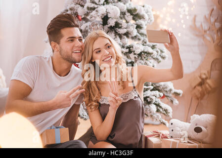 Couple positif joyeuse en tenant vos autoportraits Banque D'Images