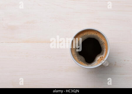Vue de dessus de café noir dans la tasse en plastique sur la table en bois blanc Banque D'Images