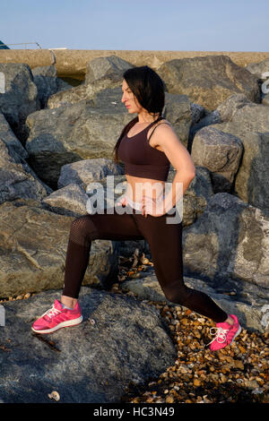 Une jeune femme exerçant au cours de sa routine quotidienne de se tenir en forme en plein air england uk Banque D'Images