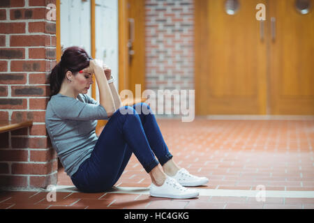 Souligné mature student sitting in locker room Banque D'Images