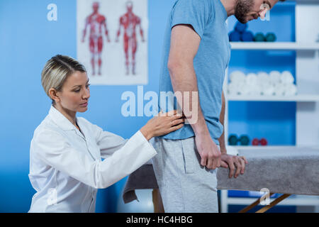 Physiotherapist examining mans retour Banque D'Images