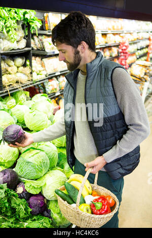 Homme buying vegetables in organic shop Banque D'Images