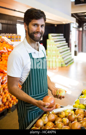 L'organisation du personnel masculin dans la section des fruits bio de supermarché Banque D'Images