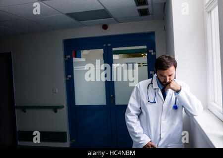 Triste doctor standing in corridor Banque D'Images