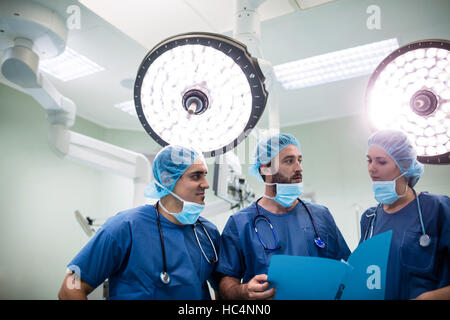 Chirurgiens discuter dossiers patients dans l'opération prix Banque D'Images