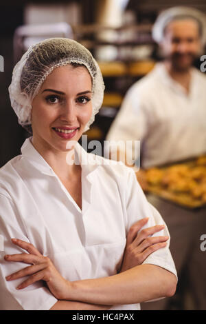 Portrait of female baker standing with arms crossed Banque D'Images