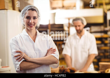 Portrait of female baker standing with arms crossed Banque D'Images