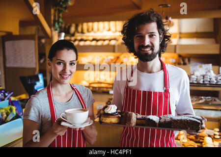 Couple tenant une tasse de café et un aliment sucré Banque D'Images