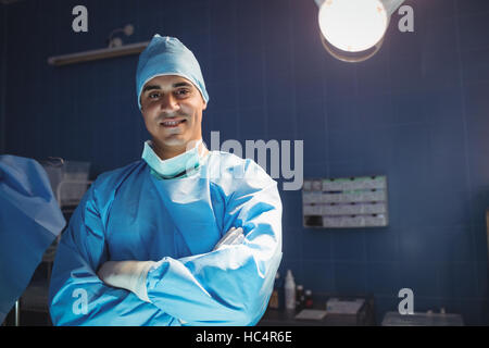 Portrait of surgeon standing with arms crossed en salle d'opération Banque D'Images