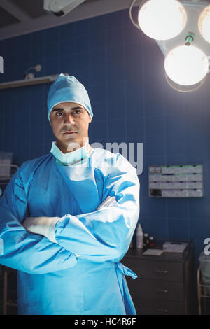 Portrait of surgeon standing with arms crossed en salle d'opération Banque D'Images