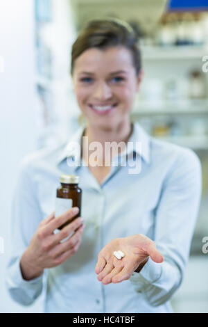 Pharmacien montrant un flacon de médicaments et les pilules en pharmacie Banque D'Images