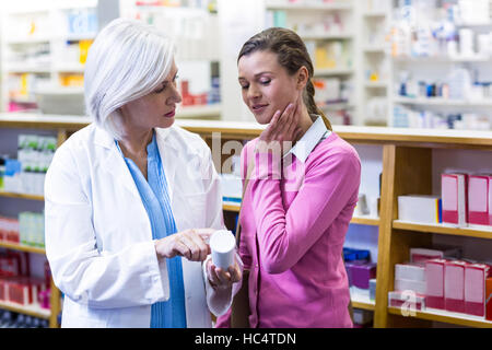 Pharmacien aider la bouteille de médicament au client Banque D'Images