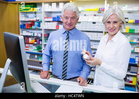 Les pharmaciens Smiling standing in pharmacy Banque D'Images