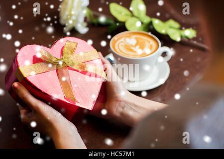 Hands holding heart shaped gift box Banque D'Images
