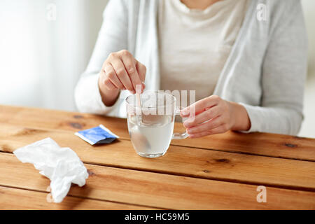 Femme en remuant de médicament en tasse avec cuillère Banque D'Images