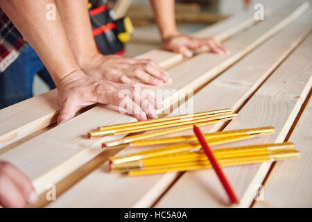 Les plus jeunes et les plus vieux carpenter sont la mesure de planches en bois Banque D'Images