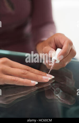 Woman pearl vernis teinté sur ses ongles soigneusement Banque D'Images