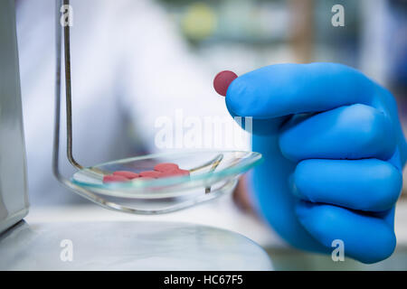 Pharmacien la mesure de comprimés avec l'échelle de la pharmacie Banque D'Images