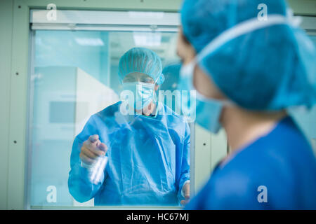 Médecin de regarder à travers un verre fenêtre Banque D'Images