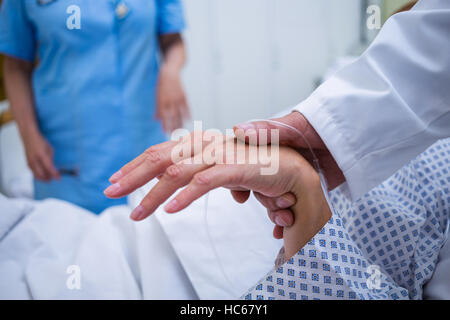 Doctor examining patients pulse Banque D'Images
