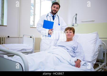 Médecin et patient Smiling at camera in hospital Banque D'Images