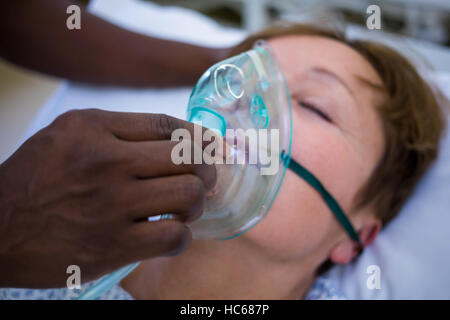 Placer l'infirmière d'un masque à oxygène sur le visage d'un patient Banque D'Images