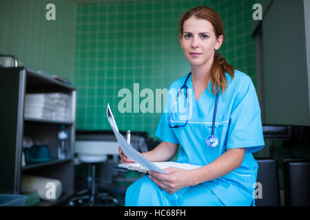 Portrait of nurse holding rapport médical Banque D'Images