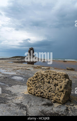 Rochers dans l'avant-plan et Noir Nab à Saltwick Bay, Yorkshire, Angleterre Royaume-uni Banque D'Images