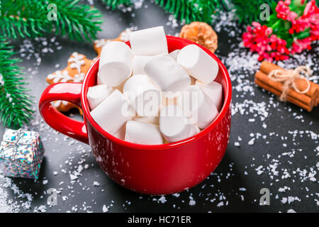 Beau fond de noël avec tasse de guimauves, d'épices et un décor de Noël sur le tableau noir Banque D'Images