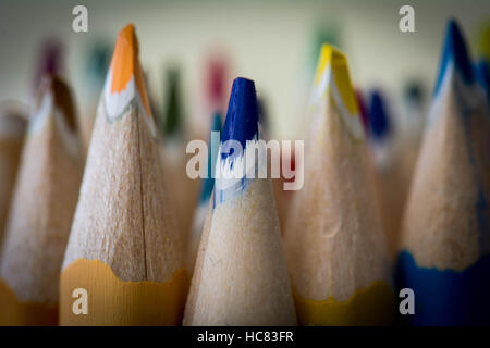 palette arc-en-ciel de crayons de couleur avec un cahier à spirale sur fond  jaune, maquette, mise à plat. rentrée scolaire, recrutement étudiant,  artiste, cours de dessin. espace de copie. papeterie pour la