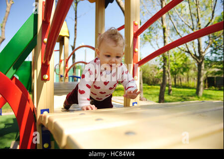 Little baby girl excité de ramper sur aire Banque D'Images