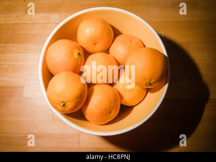 Oranges clémentines dans un bol sur le comptoir de bois Banque D'Images