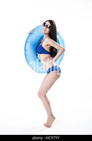 Side view of young smiling woman in bikini slim posant avec un tube Banque D'Images