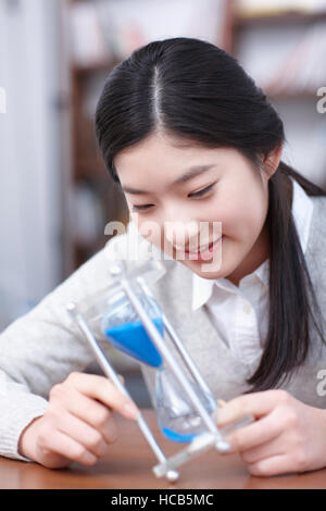 Portrait of smiling 13 ans avec sablier Banque D'Images