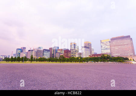 Coucher de soleil pourpre surplombant le centre-ville de Marunouchi skyline at Dusk vu de la Place du Palais Impérial à Tokyo, Japon Banque D'Images