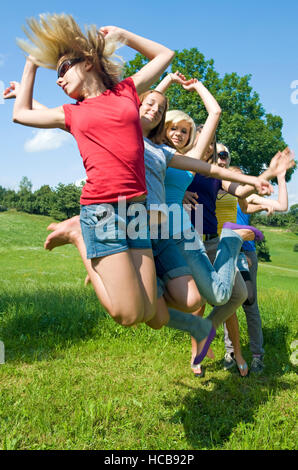 Teenage Girls jumping in meadow Banque D'Images