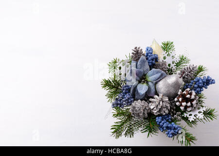 Noël arrière-plan avec decor et poinsettias en soie bleue. Arrangement de fleurs de Noël artificiel avec des pommes de pin et branches de sapin. Ch Banque D'Images