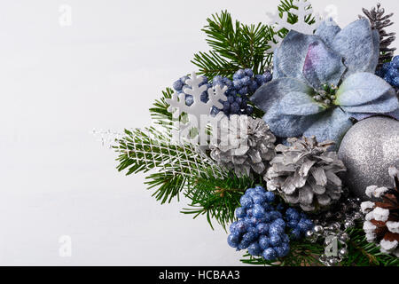 Décoration de Noël avec des flocons et poinsettias en soie bleue. Arrangement de fleurs de Noël artificiel avec des pommes de pin et branches de sapin. Chr Banque D'Images