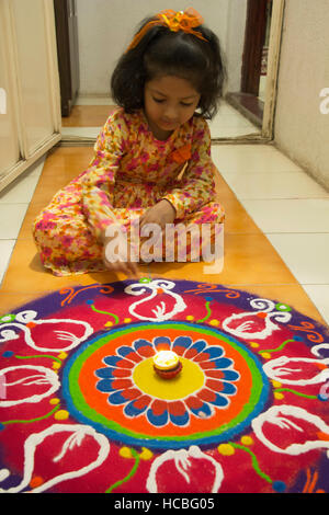 Faire de l'enfant indien rangoli en face de la maison pendant la saison du festival, Pune, Maharashtra, Inde Banque D'Images