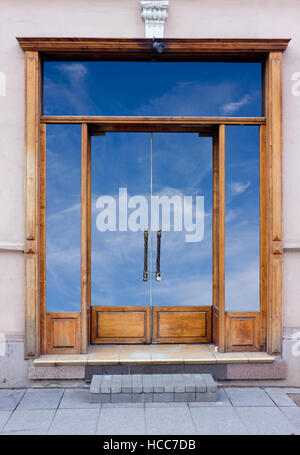 L'entrée fermée en bois vintage cafe collage. Des portes et fenêtres en verre est isolé avec patch, dans le bleu du ciel se reflète. Banque D'Images