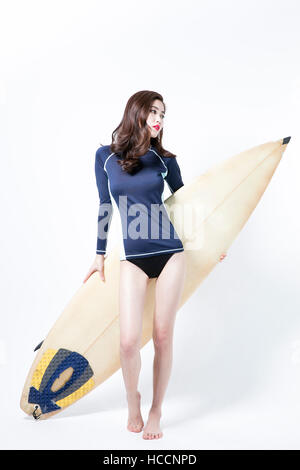 Jeune femme slim en rash guard et costume de bain posant avec voile Banque D'Images